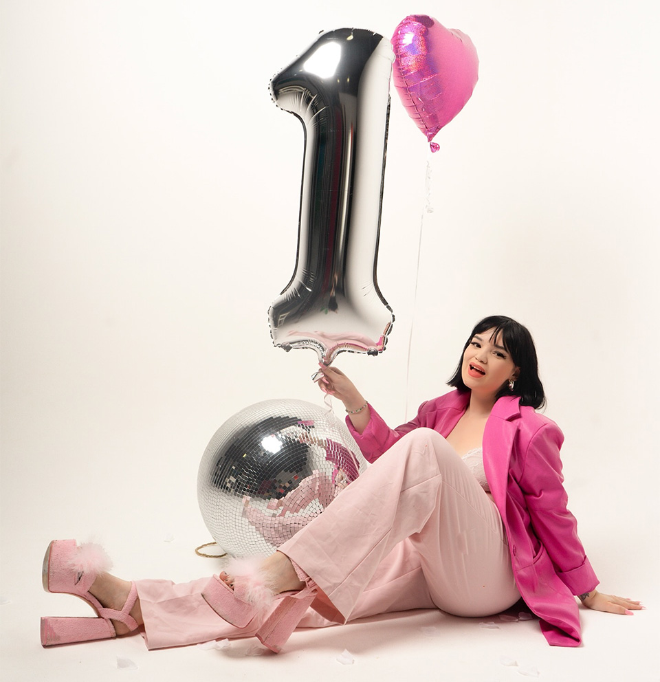 Alice Potter holding a silver 1 balloon to celebrate the 12 month anniversary of her business