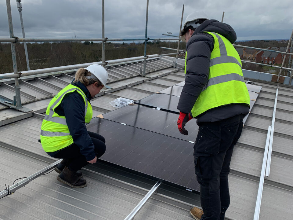 two people on roof installing solar panels